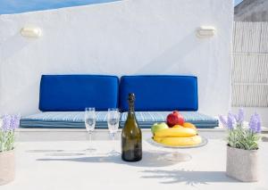 a table with a bottle of wine and fruit on it at Mykonos Panorama with Private Terrace & Sea View in Mikonos