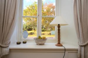 a window with a lamp and a bowl of fruit on a window sill at Darroch Beag in Saint Catherines