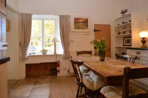 een eetkamer met een tafel en stoelen en een raam bij Darroch Beag in Saint Catherines