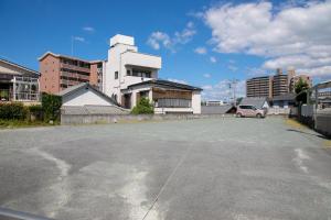 un parcheggio vuoto con un edificio sullo sfondo di Grand Hotel Seifuso a Ōmuta
