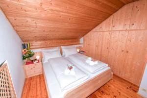 a bed in a room with a wooden ceiling at Appartamenti Chedul in Selva di Val Gardena