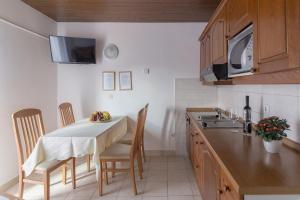 una cucina con tavolo, sedie e lavandino di Apartments Fine Stay Bled a Bled