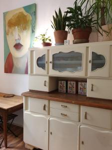 a white dresser with plants on top of it at Apartment center Friedrichshain in Berlin