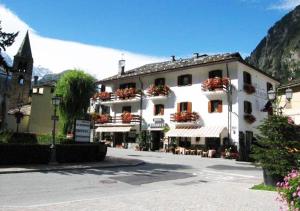 un grande edificio bianco con fiori sui balconi di Hotel Bucaneve a Pré-Saint-Didier