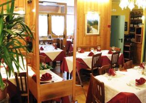 a restaurant with tables and chairs with red napkins at Hotel Bucaneve in Pré-Saint-Didier