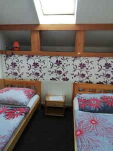 two bunk beds in a room with floral wallpaper at Penzion Horka in Horka nad Moravou