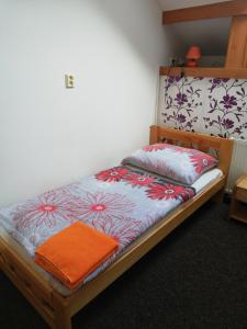 a bed in a room with an orange towel on it at Penzion Horka in Horka nad Moravou