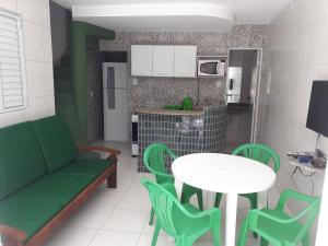 a living room with a table and chairs and a kitchen at Chalés Village Gales in Maragogi