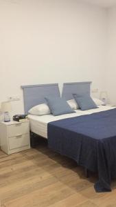 a bedroom with two beds with blue sheets and a nightstand at ENTRETORRES Apartamento Turístico in Olivenza