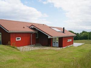 une maison rouge avec un toit rouge dans l'établissement 10 person holiday home in Augustenborg, à Asserballeskov