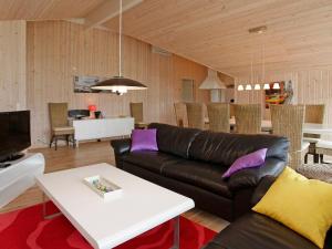 a living room with a couch and a table at 12 person holiday home in R dby in Kramnitse