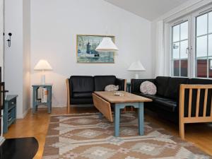 - un salon avec un canapé noir et une table basse dans l'établissement 6 person holiday home in Aabenraa, à Åbenrå