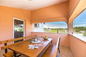 een eetkamer met een houten tafel en een groot raam bij Villa Piljan in Bokordići