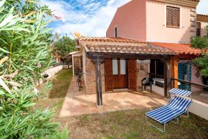 a house with two blue chairs in the yard at Casa Podda in San Teodoro