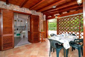 a dining room with a table and chairs and a kitchen at Casa Podda in San Teodoro +14 photos