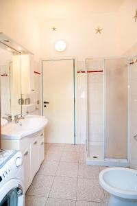 a bathroom with a shower and a sink and a washing machine at Casa Podda in San Teodoro