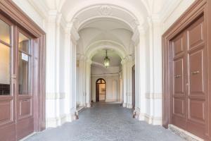 ローマにあるPasseggiata di Ripettaの白壁・扉建築廊下
