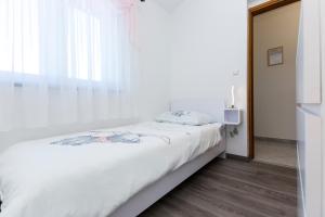 een slaapkamer met een wit bed en een raam bij Villa Piljan in Bokordići +35 foto's