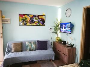 ein Wohnzimmer mit einem Sofa und einer Uhr an der Wand in der Unterkunft 2 BR Sorrento Oasis in Manila