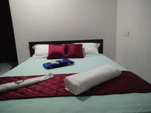 a bed with red and white pillows on it at Golden Nest in Rāmamangalam