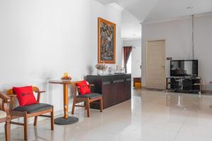 sala de estar con mesa, sillas y TV en RedDoorz near Siloam Karawaci 3 en Tangerang