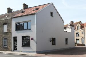 een wit huis met een rood dak bij Loft vakantiehuis in Veurne