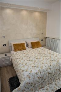 a bedroom with a large bed with a floral comforter at Carrara Hospital Home in Bergamo