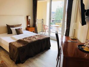 a bedroom with a bed and a desk and a balcony at Weinquartier Burggarten in Bad Neuenahr-Ahrweiler