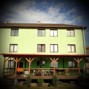 a large green house with tables and chairs in front of it at Pension Jezdecké centrum Kočík in Stružná