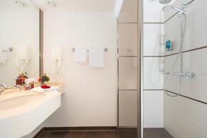 een badkamer met een wastafel en een douche bij Hotel Grossfeld in Bad Bentheim