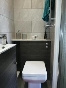 a bathroom with a white toilet and a sink at Charming pink house with perfect location in Whitstable