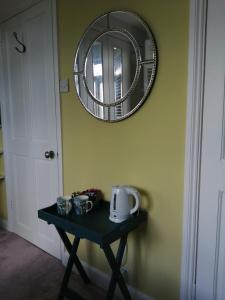 a table in a room with a mirror on the wall at Charming pink house with perfect location in Whitstable