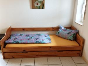 a wooden bench with two pillows on it at Ferienwohnung Punkt-Schönstein in Kappel-Grafenhausen