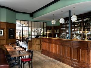 een restaurant met houten tafels en een bar bij The Coach in Londen