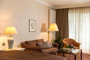 Hotel Grossfeld في باد بينثيم: غرفه فندقيه بسرير واريكه