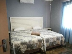 a bedroom with a bed with a pillow on it at Umsinsi Cottage in Hluhluwe