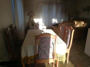a dining room with a table with chairs and a couch at Umsinsi Cottage in Hluhluwe