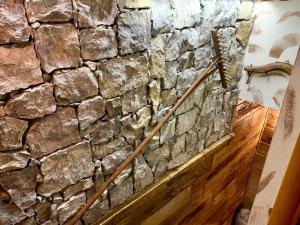 a stone wall in a room with a wooden floor at ALLA STALLA Suite & Chalet in Piazzatorre +57 photos