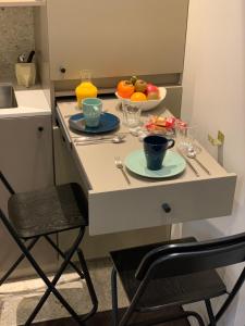 a small kitchen with a table with a bowl of fruit at PARIS RIVOLI NOTRE DAME Chambre d'Hôtes Studio Private in Paris