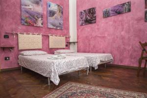 2 Betten in einem Zimmer mit rosa Wänden in der Unterkunft A Casa Fachin Room & Breakfast in Bologna
