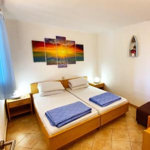 a bedroom with a bed and two paintings on the wall at Lumbarda Driftwood in Lumbarda