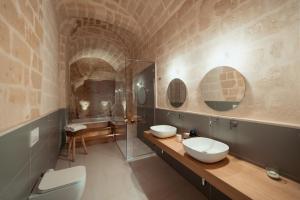 uma casa de banho com 2 lavatórios e um chuveiro em Endea Suite Rooms & Lounge SPA em Matera