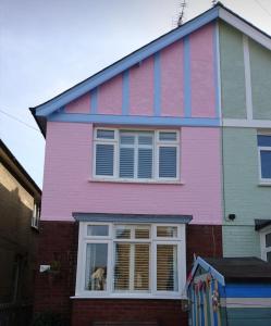 a pink house with a dog in a window at Charming pink house with perfect location in Whitstable