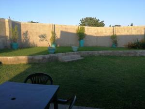 a backyard with a table and a fence with plants at Umsinsi Cottage in Hluhluwe