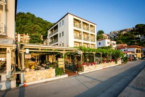 a street with a building with flowers and plants at Kenta Beach Hotel in Agios Ioannis Pelio