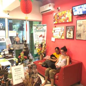 un hombre y una mujer sentados en un sofá en una tienda en Woodpecker Lodge, Kuching, en Kuching
