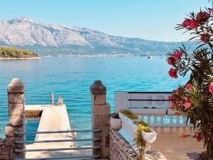 a dock with a view of the water and mountains at Lumbarda Driftwood in Lumbarda