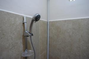 La salle de bains est pourvue d'une douche avec un pommeau de douche. dans l'établissement RedDoorz near Millenium Waterpark Palu, à Palu