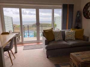 a living room with a couch and a large window at The Lookout in Mundesley