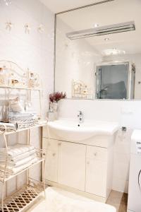 a white bathroom with a sink and a mirror at Apartament Lawendowa Przystań in Międzyzdroje